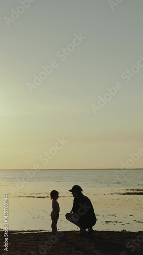 Vertical video. Silhouette of a caring Parent and Child enjoying their time at the Beach, capturing joy