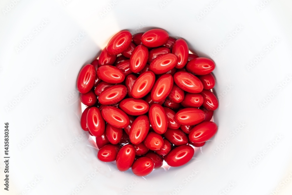 Red pills and supplements inside white jar