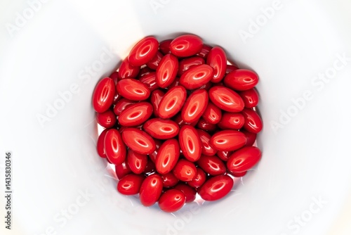 Red pills and supplements inside white jar