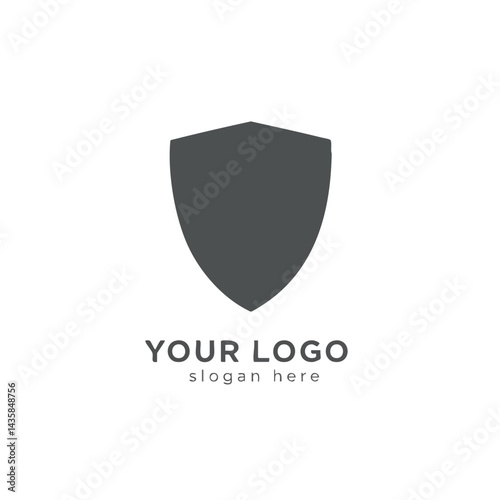 Simple dark grey or black shield silhouette logo icon representing security, protection, safety, or strength.
