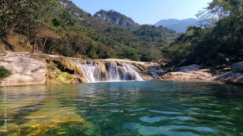 Fototapeta premium Mountain waterfall cascading into tranquil pool, lush green forest backdrop