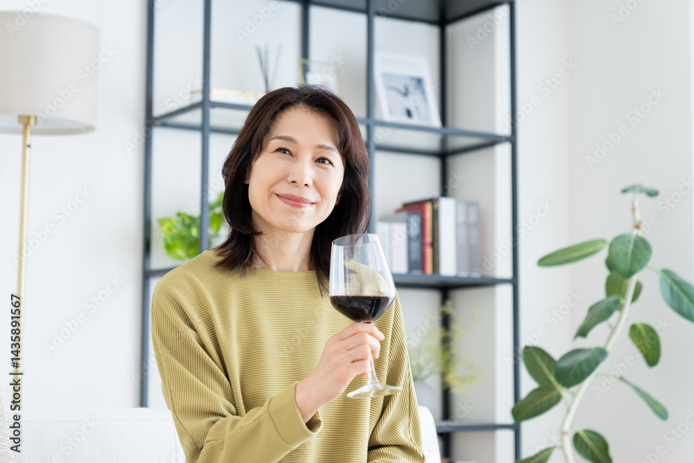 リビングでワインを飲むミドルの女性 リビングでワインを飲むミドルの女性