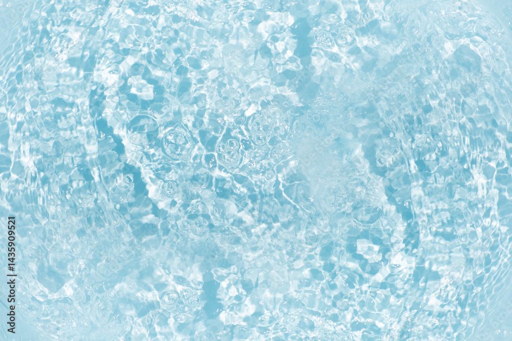 Obraz premium Blue water with ripples on the surface. Defocus blurred transparent blue colored clear calm water surface texture with splashes and bubbles. Water waves with shining pattern texture background.