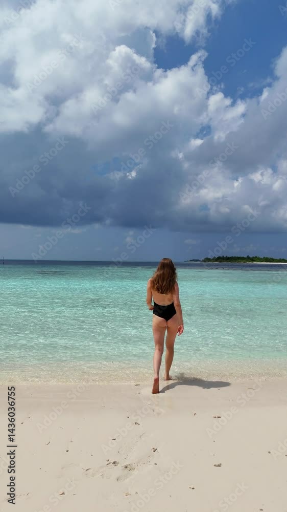 woman runs enters into the tropical beach water at sunset on white sand, surrounded by calm waves and soft golden light, summer vacation, traveling, family resort, happiness woman runs enters into the tropical beach water at sunset on white sand, surrounded by calm waves and soft golden light, summer vacation, traveling, family resort, happiness