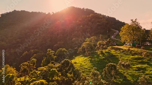 Charming countryside town nestled in lush mountains. Greenery surrounds quaint houses. Peaceful aerial view.