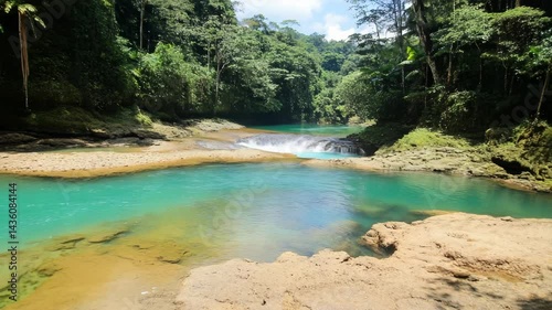 Wallpaper Mural Idyllic scenery of turquoise river flowing through the lush tropical jungle landscape with a small waterfall, creating a serene and tranquil atmosphere. Torontodigital.ca