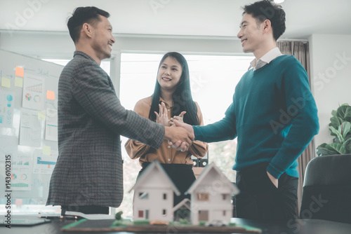 Obraz na płótnie Real estate businessmen shake hands to make an agreement to sell a house with a customer with a contract document. w salonie