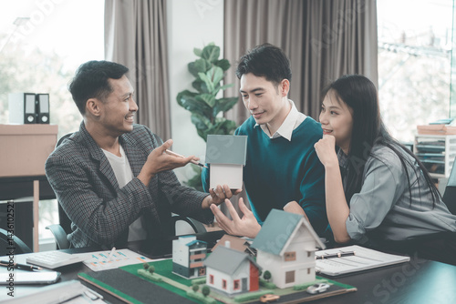 Business team signing investment agreement for residential real estate. Group of professionals in suits meeting in office with financial agreement documents on table.