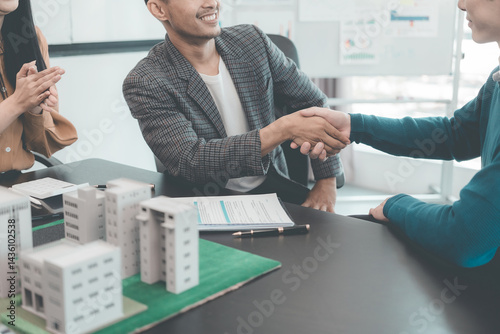 Obraz na płótnie Real estate businessmen shake hands to make an agreement to sell a house with a customer with a contract document. w salonie