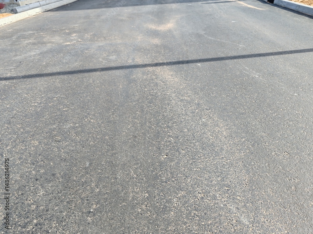 Fototapeta premium Asphalt road, Smooth asphalt road. The texture of the tarmac, top view. Urban landscape road. Close-up horizontal view of new asphalt road