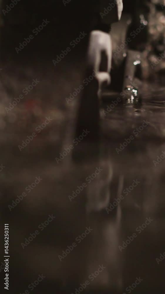 Lifting bucket with coal slag out of container with dirty water closeup. Cooling burnt rock fuel leftovers with liquid in industrial plant workshop