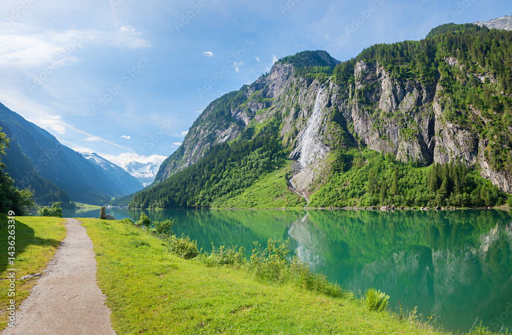 walkway along artificial lake Stillupspeicher, green spring landscape tyrol