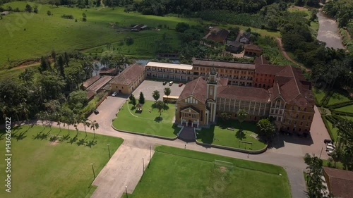 Drone captures a historic church and convent nestled amidst lush tropical mountains. Spiritual sanctuary in nature's embrace