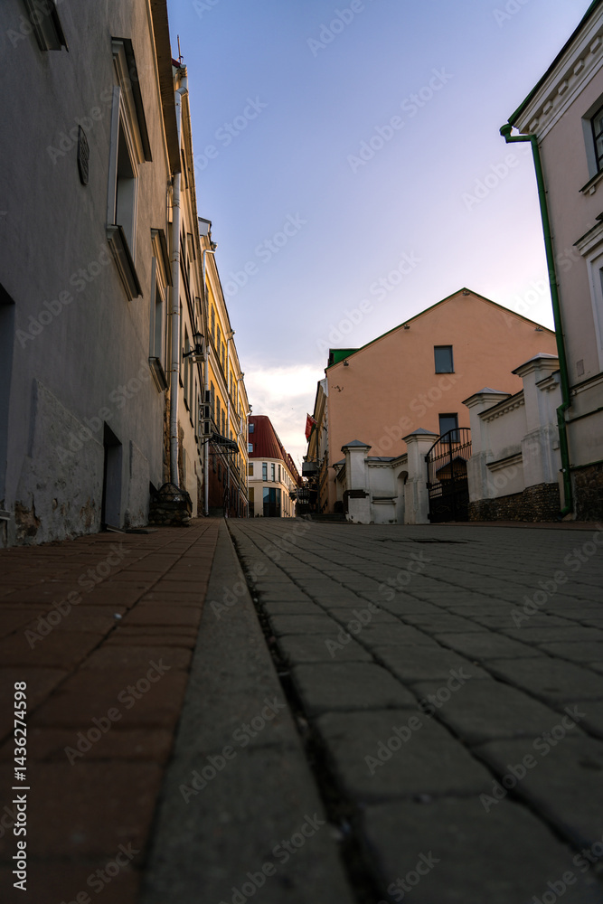 Fototapeta premium Paving stones in the old town. Evening, sunset sky. Facades of old buildings
