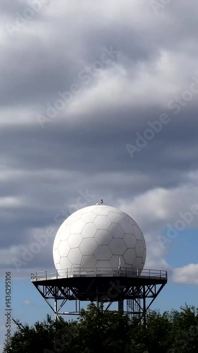 Vertical timelapse of white running on blue sky over airport meteorology radar 