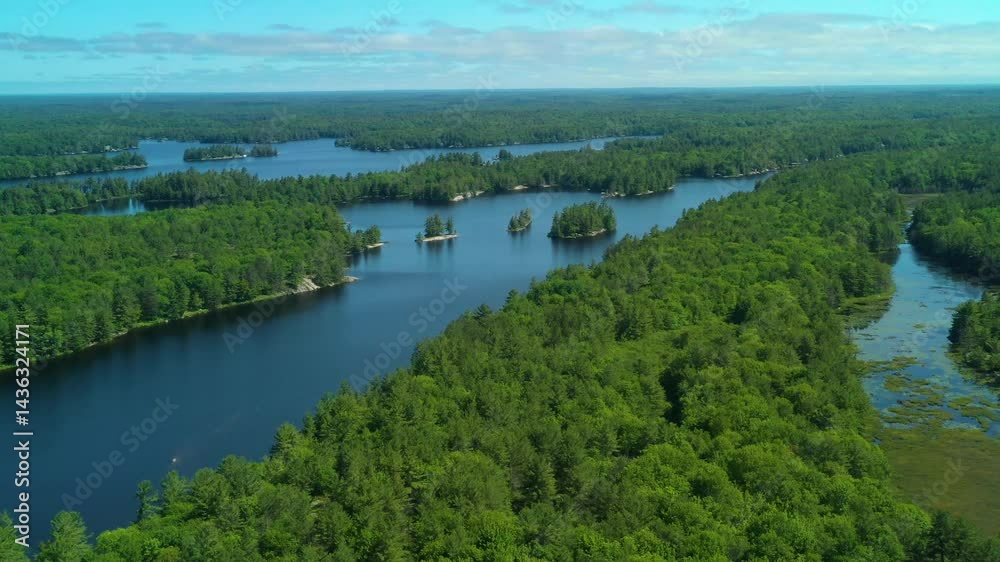 Flying high above a lake with small islands and surrounded by rural forests during the summer in cottage country. Flying high above a lake with small islands and surrounded by rural forests during the summer in cottage country.