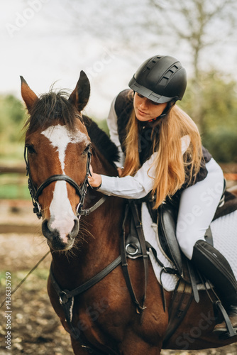 A young female jockey is sitting on her horse in show jumping training. Preparing for the competition.