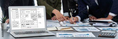 Panorama shot analyst team utilizing BI Fintech to analyze financial report with laptop. Businesspeople analyzing BI data dashboard displayed on laptop screen for business insight. Prodigy