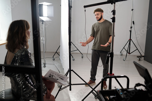 Full length shot of male director instructing unrecognizable actress in studio during video shoot copy space