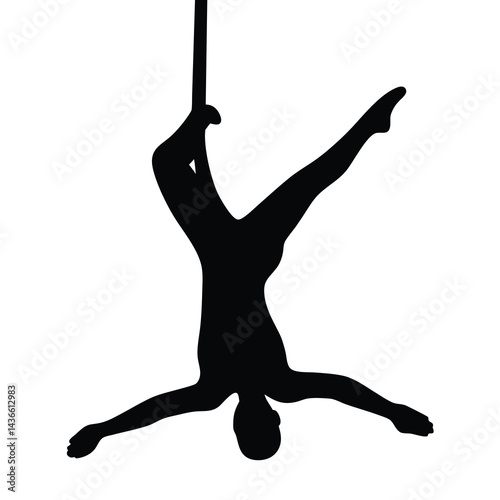 Silhouette of a graceful aerial acrobat performing a complex pose on silks