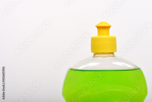 Obraz na płótnie A close-up shot shows a clear plastic bottle filled with bright green dish soap and capped with a yellow lid w salonie