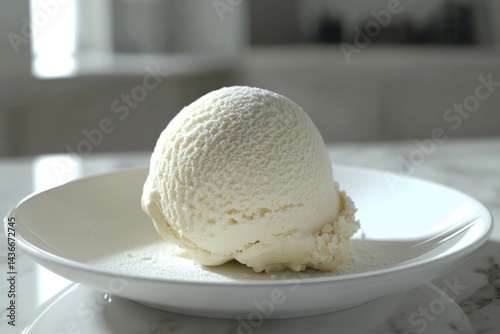 Delicious scoop of creamy vanilla ice cream served on a white plate with a clean marble background