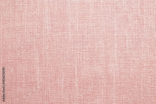 Close-up view of a light pinkish-red woven fabric.  Its texture is clearly visible, with subtle variations in the weave