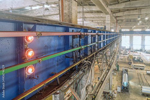Trolley busbar with light indicator pointer. Current lead for power supply of electric bridge overhead crane.