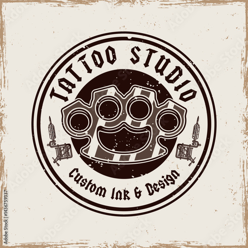 Vintage tattoo studio emblem with brass knuckles and tattoo machines. Classic monochrome vector illustration in retro style, perfect for badges, t-shirt prints and tattoo related designs