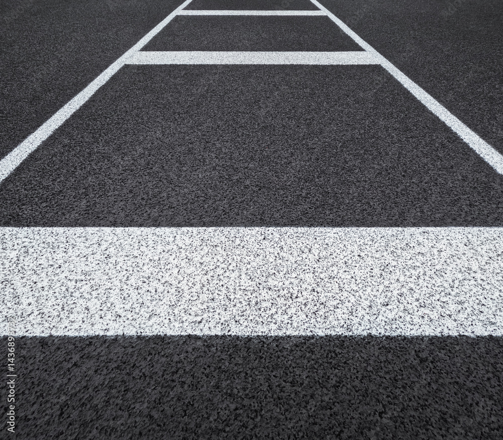 Fototapeta premium Textured black track or road surface with thick horizontal lines. Artificial rubber black surface of a running track or road.