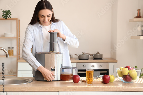Young woman making apple ju...