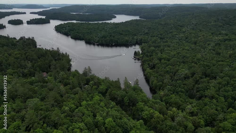 Aerial view of a motorboat making circles in the water of a lake in Canada - Vue aérienne d'un bateau à moteur faisant des ronds dans l'eau d'un lac au Canada