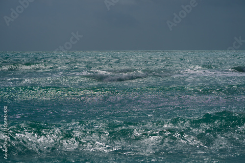 Sea background. Blue ocean. Sandy ocean beach. Ocean waves. Summer seaside. Tropical ocean coastline. Exotic turquoise water. Foamy wave splash on sea. Sunny beach view.