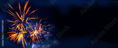 Obraz na płótnie Brilliant orange and blue fireworks against a deep black night sky with copy space for festive or celebratory themes w salonie