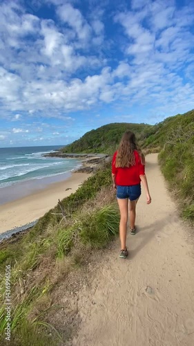 Woman walking along Coastal Track with views of beautiful beaches and ocean, Noosa National Park, Queensland, Australia