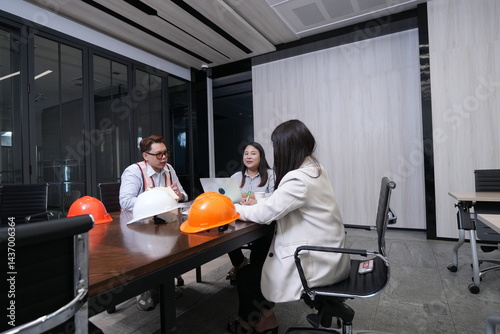 Construction team, engineers and sales marketing team hold a meeting on the progress of the project's construction in the conference room.
