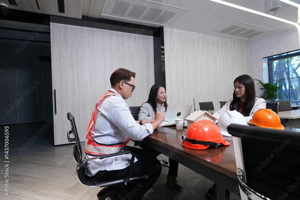 Construction team, engineers and sales marketing team hold a meeting on the progress of the project's construction in the conference room.