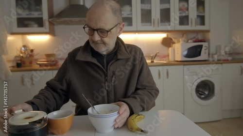 Senior Man Having Breakfast Alone in a Kitchen Setting
