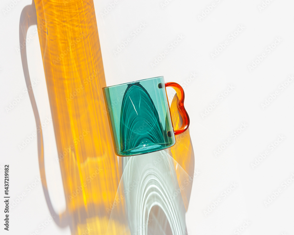 Modern Glass Cup with Vibrant sunlight Shadows, Minimal photo of transparent green colored glass mug. Golden light reflections and shadow on white background, lifestyle design, homeware decor