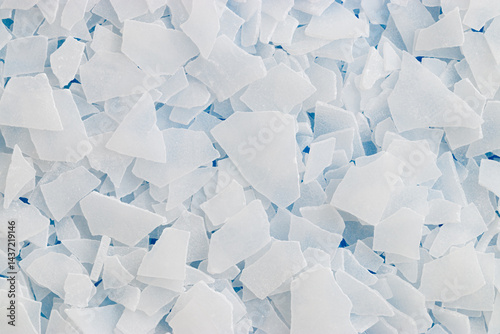 Close-up of magnesium flakes on turquoise background, salt crystalline texture. Natural White sea salt as wellness or spa products for bath soaks or relaxation, self-care or sustainable living