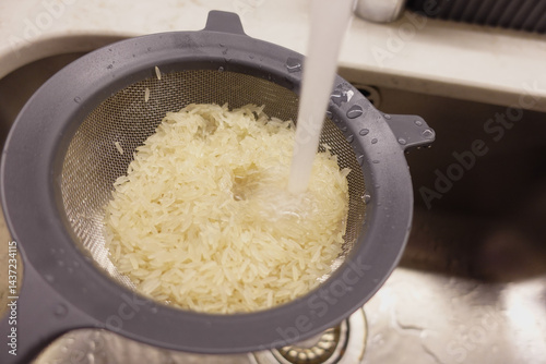 Cooking rice by rinsing it in a colander over a sink