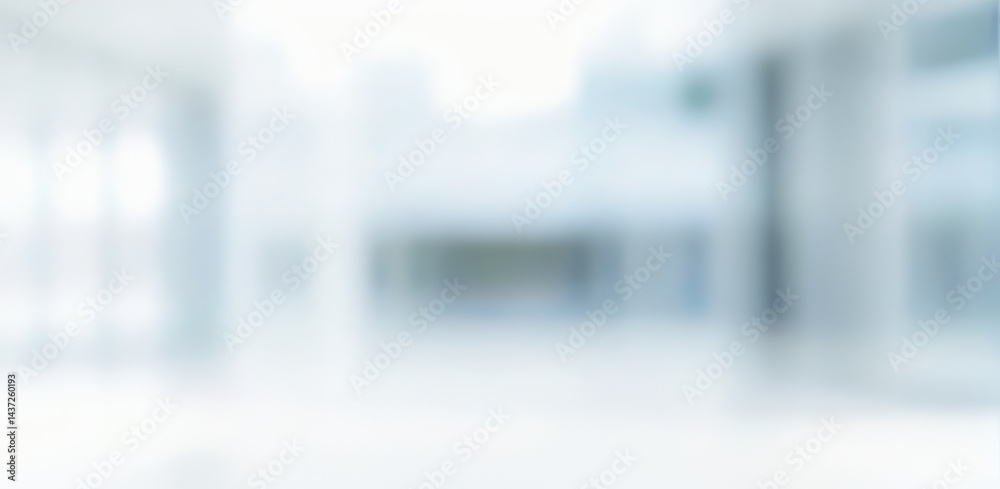 Blurred interior space with white and light blue tones suggesting a modern building. Blurred interior space with white and light blue tones suggesting a modern building.