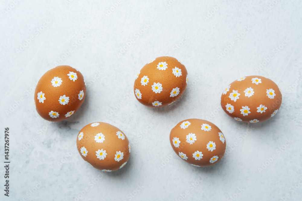Hand-painted Easter eggs with daisies on light background. Easter bacground. Hand-painted Easter eggs with daisies on light background. Easter bacground.