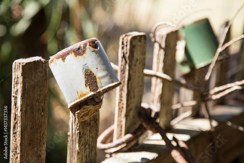 Old enamel tin cups on wooden fence pickets
