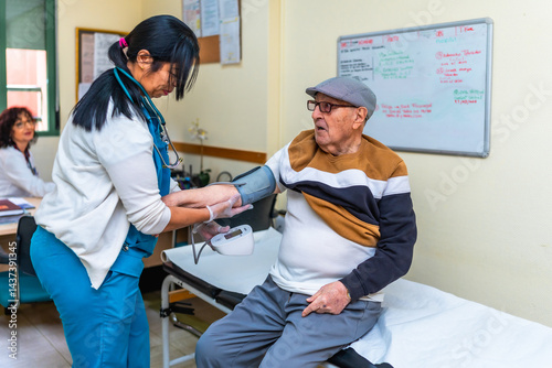 Nurse measuring blood pressure of senior man in nursing home
