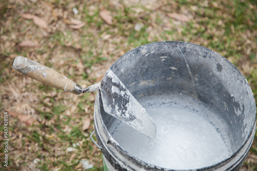 Tilers trowel on the edge of bucket or mortar photo