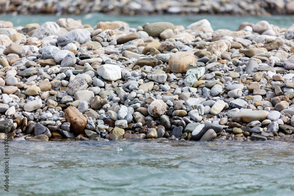 Obraz premium A rocky shoreline with a body of water in the foreground