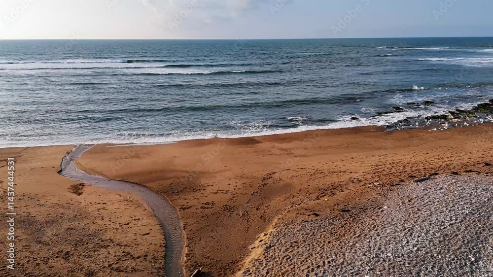 Recul au drone au-dessus des vagues, sa plage de sable et galets du pays basque