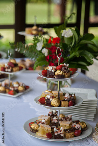 Cakes and sweets on three tiered platter at event photo
