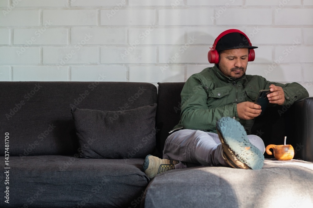 Fototapeta premium adult male with headset checks his cell phone